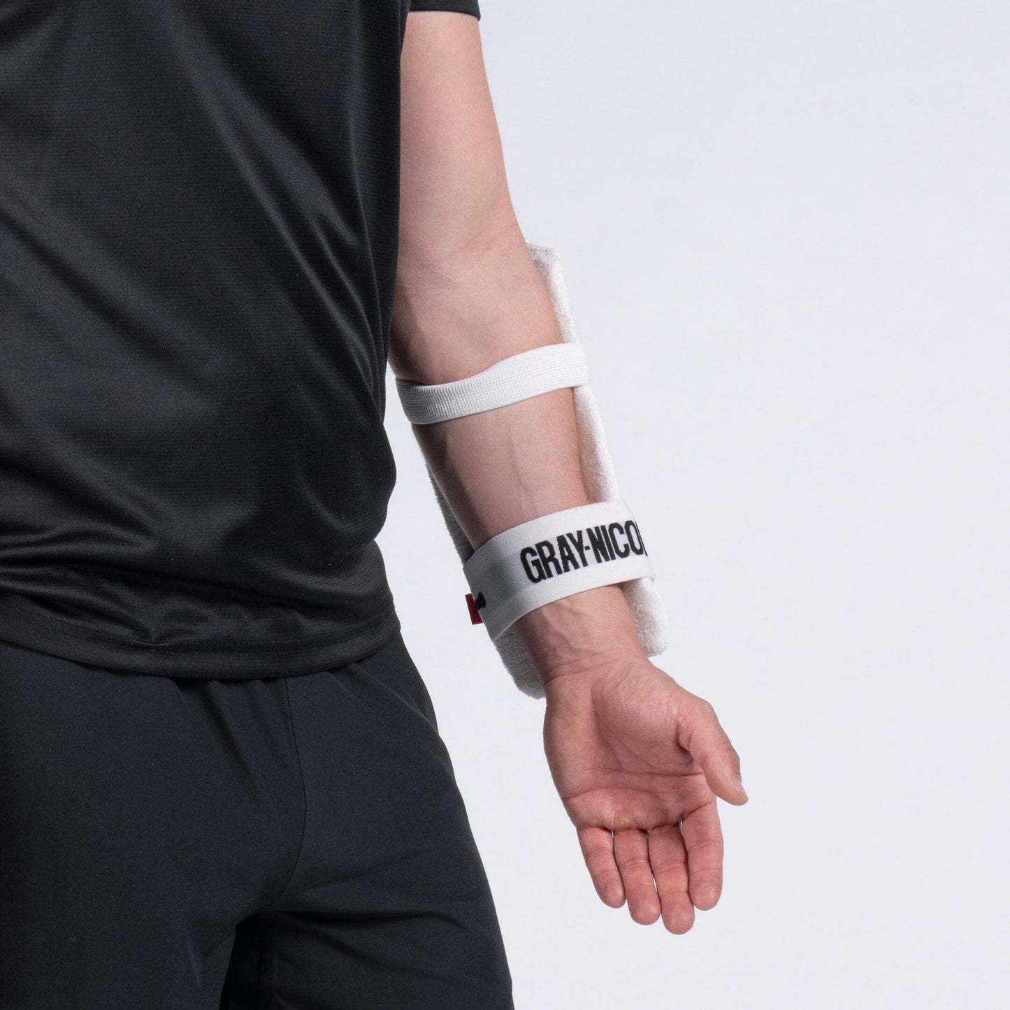 Close-up of Gray-Nicolls Test Armguard showing elastic strap and contoured protection on forearm