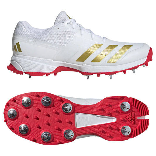 Adidas 22YDS cricket shoe in white with gold stripes and red sole, featuring metal spikes for grip and performance