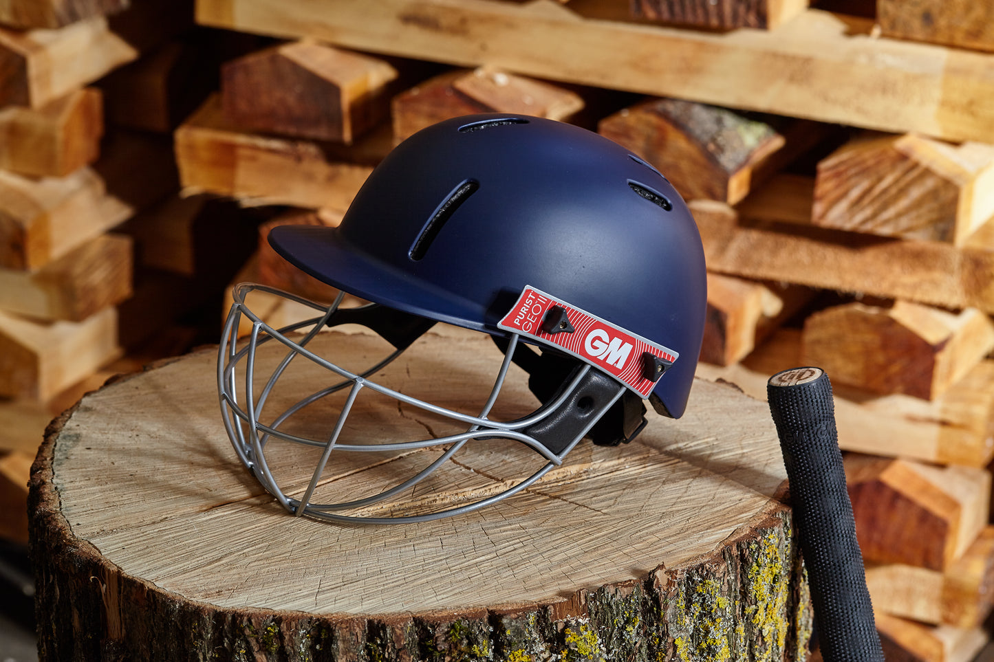 Lifestyle image of GM Purist GEO II navy helmet placed outdoors on wooden surface