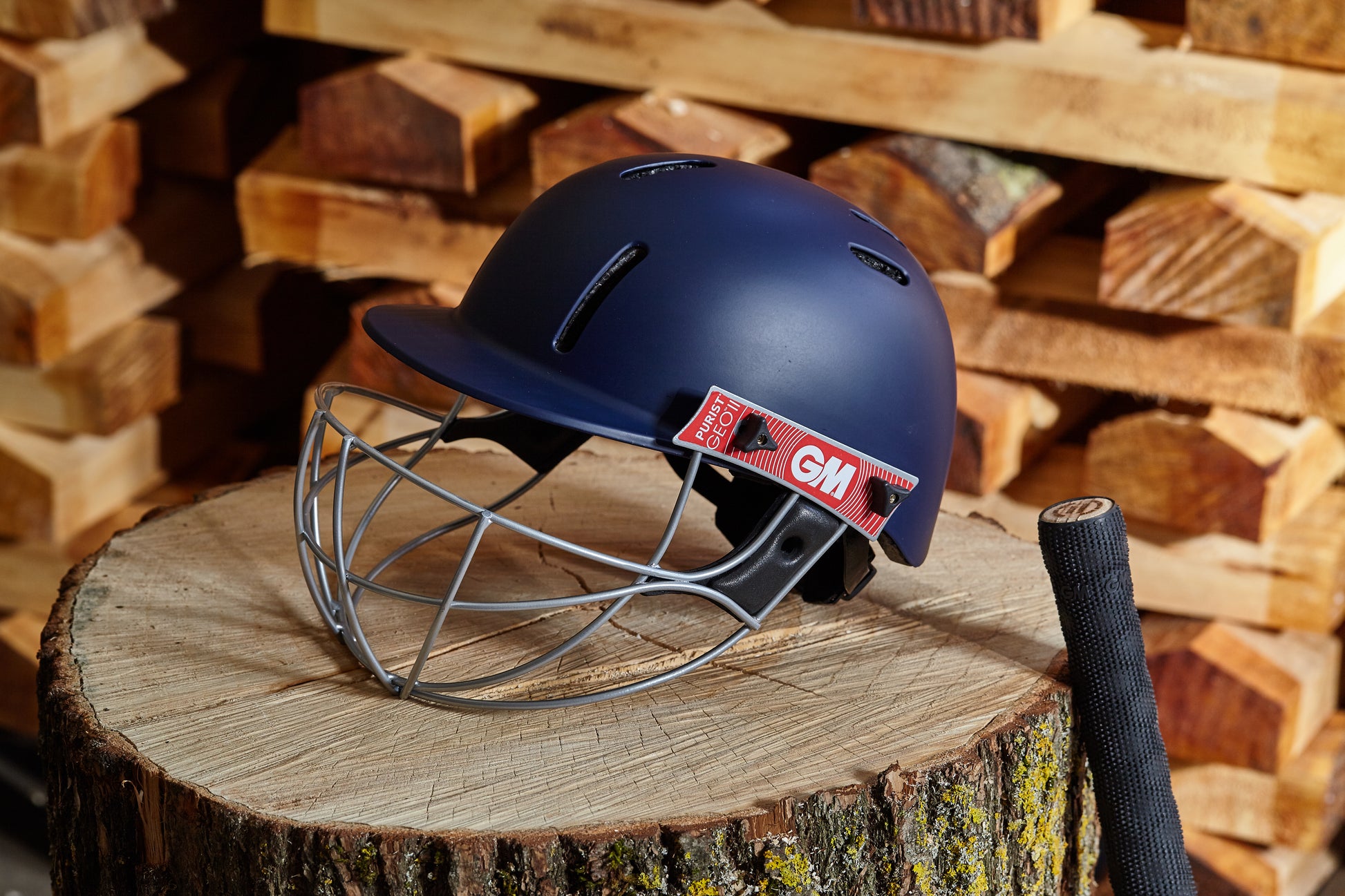 Lifestyle image of GM Purist GEO II navy helmet placed outdoors on wooden surface