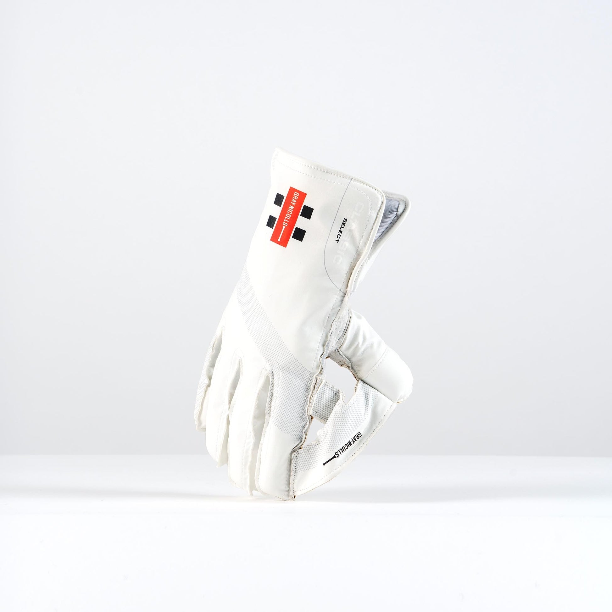 Angled backhand view of Gray-Nicolls Classic Select wicketkeeping gloves with traditional red-and-black logo