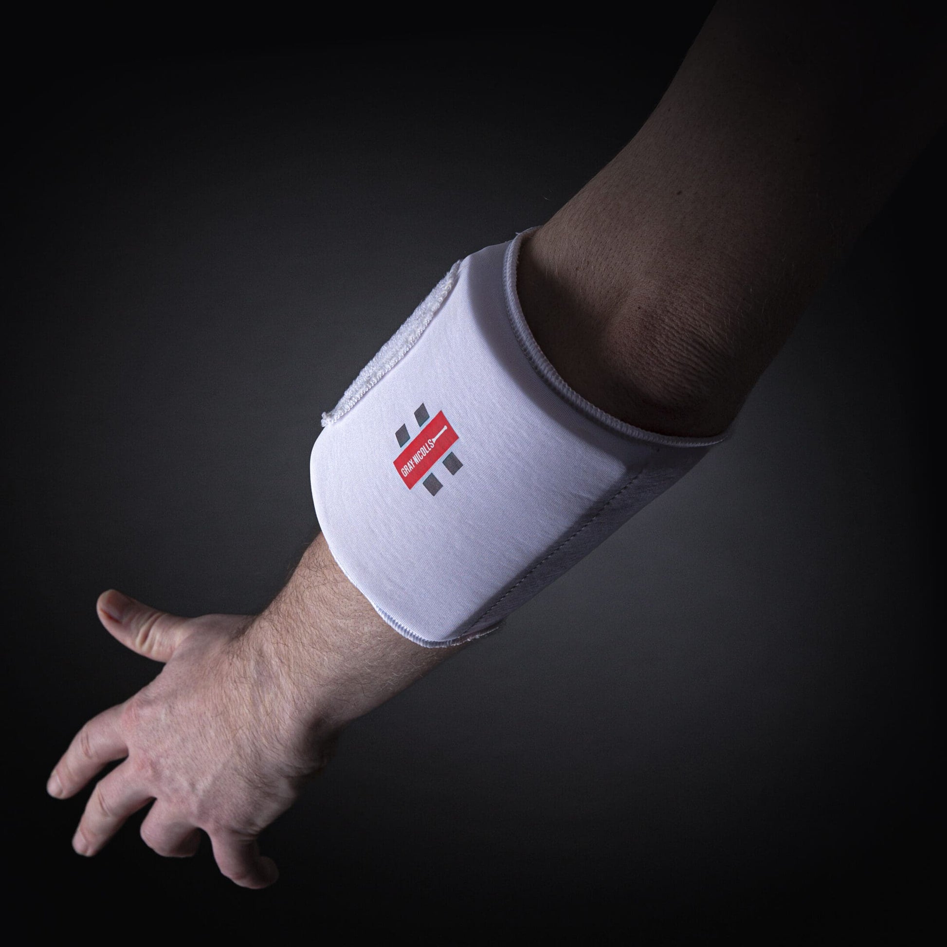 Gray-Nicolls Mini Pro Armguard being worn on arm, showcased under dark lighting