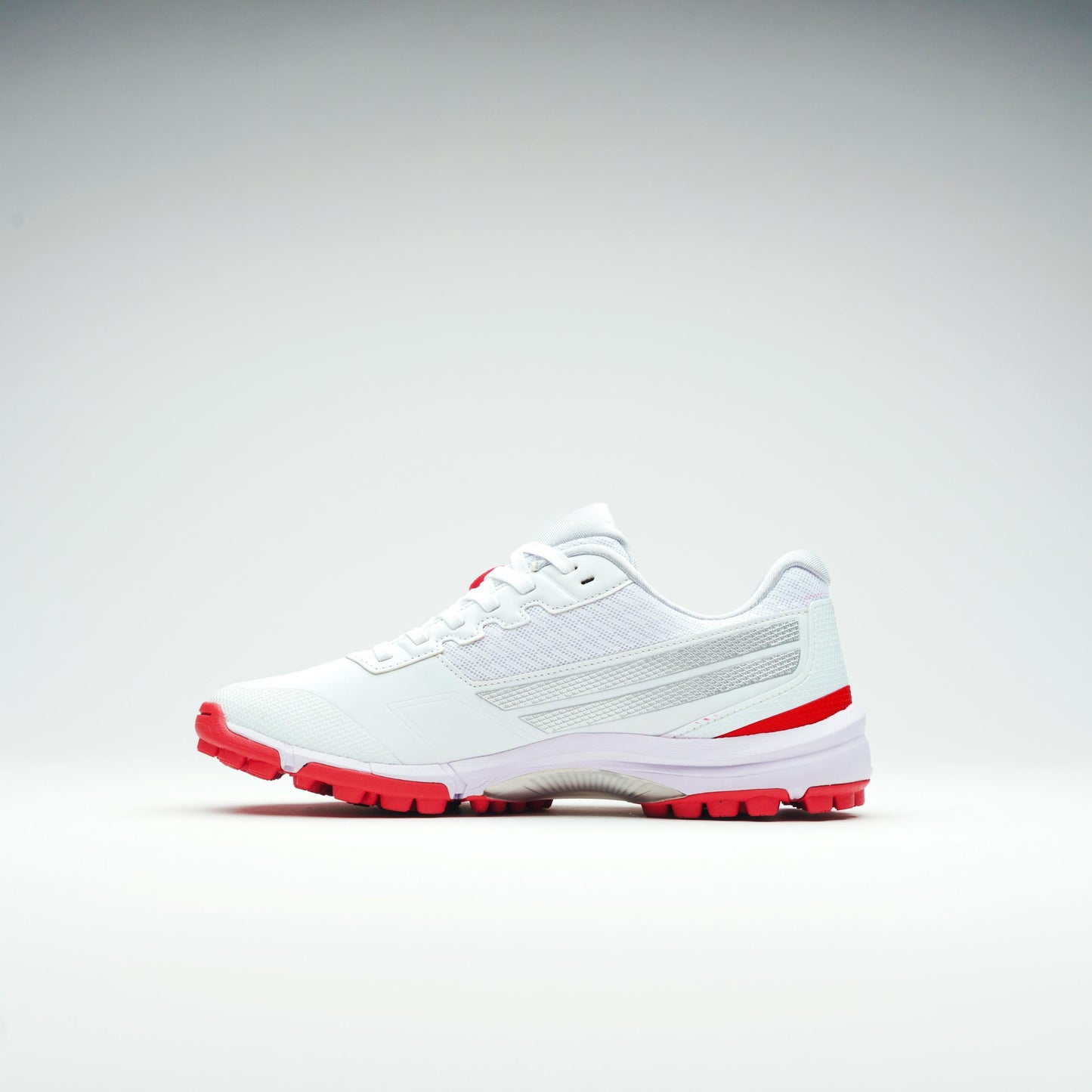 Side view of lightweight cricket shoes with red rubber sole