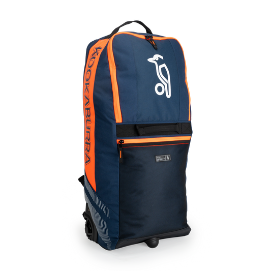 Navy and orange Kookaburra WD6000 Wheelie Duffle Bag shown upright with front branding