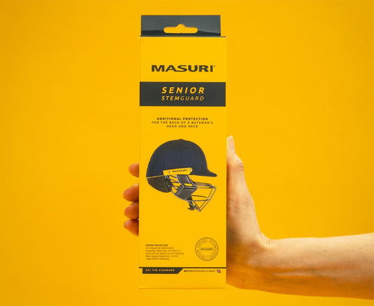Masuri StemGuard Elite Senior in retail packaging, held in hand against yellow background