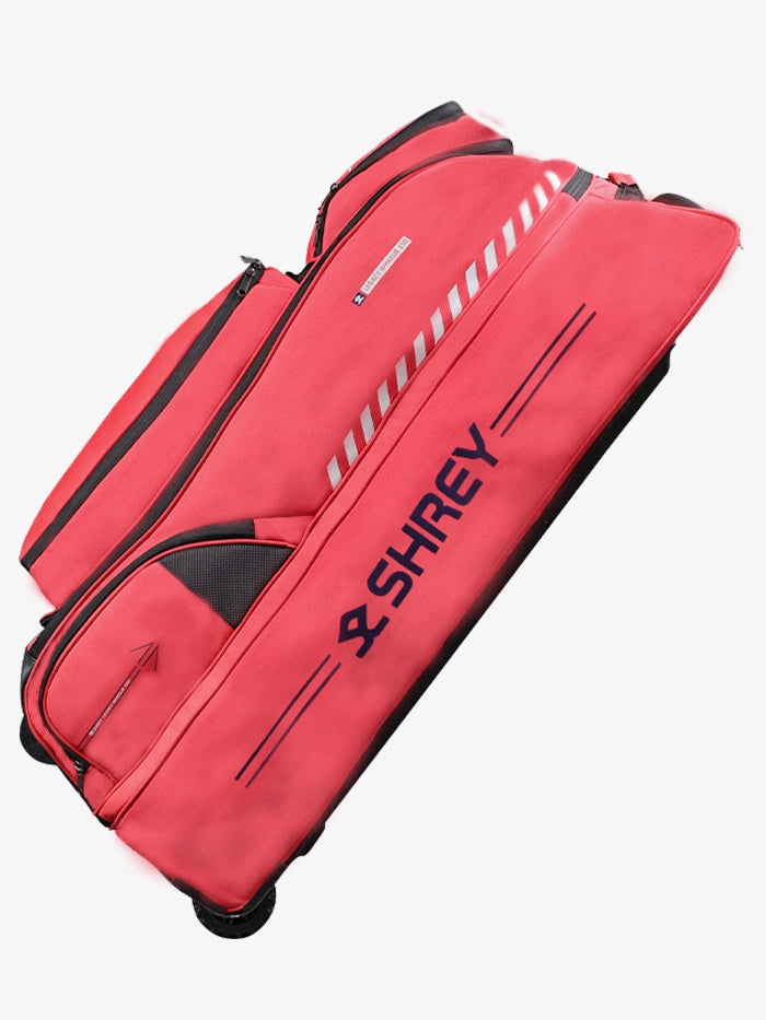 Angled side view of the bag in red showcasing handle and wheels