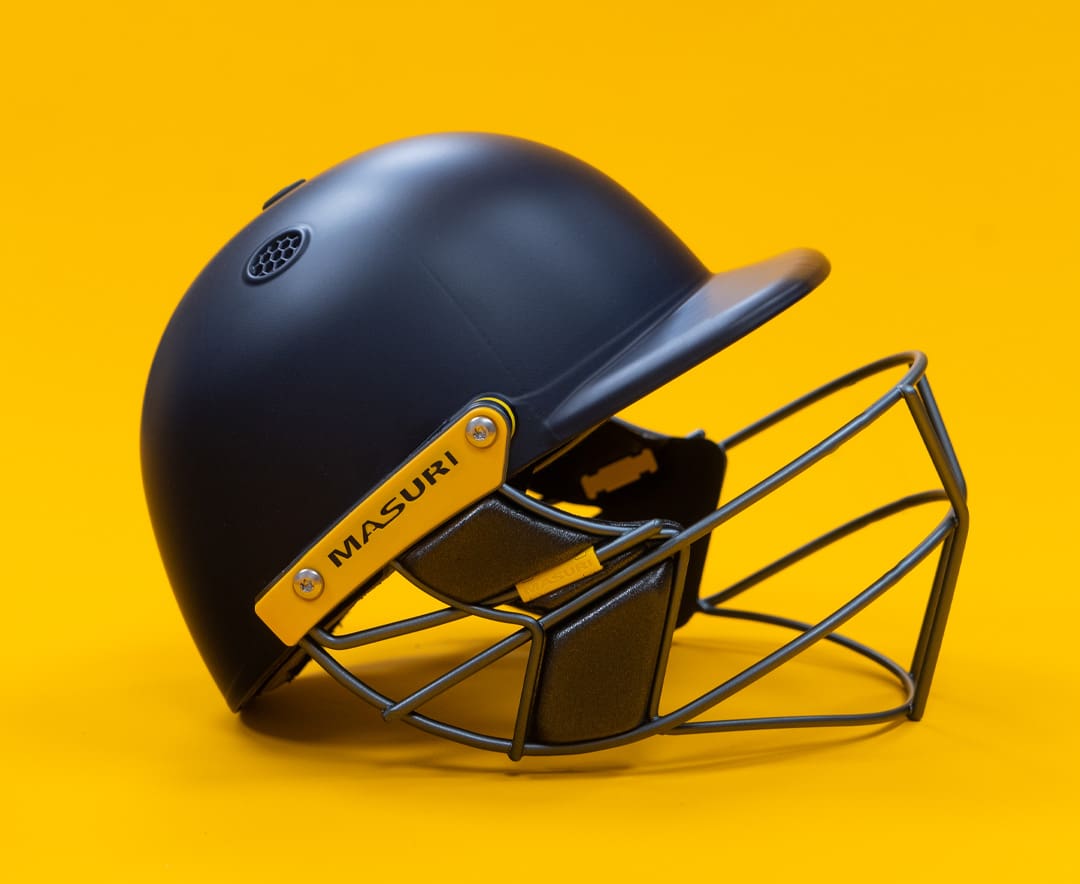 Masuri cricket helmet in matte Navy with yellow accents and steel grille, offering premium head protection for professional and amateur cricketers.