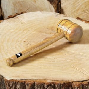 GM cricket bat mallet in centre frame pictured on top of a tree trunk